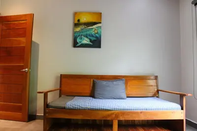 a wooden bench in a room with a painting on the wall at Nosara Verde in Nicoya