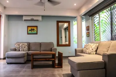 a living room with two couches and a couch and a table at Nosara Verde in Nicoya