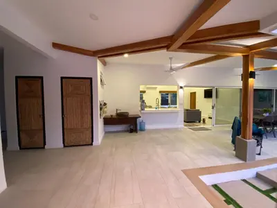 an open living room with wooden ceilings and wooden doors at Casa Las Olas in Esterillos