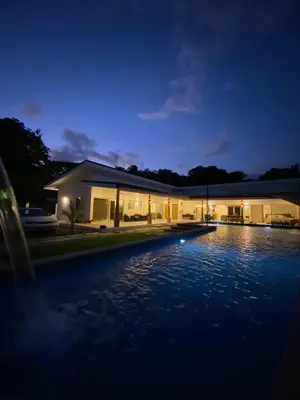 a house with a swimming pool at night at Casa Las Olas in Esterillos