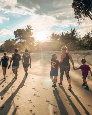a group of people walking on the beach at Casa Las Olas in Esterillos