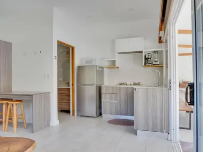 a kitchen with stainless steel appliances and a table at Casa Las Olas in Esterillos