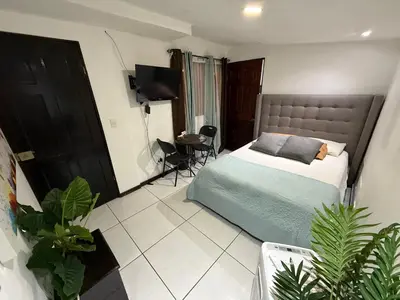 a bedroom with a bed and a table in it at Alojamiento Cereza 1 in Alajuela City