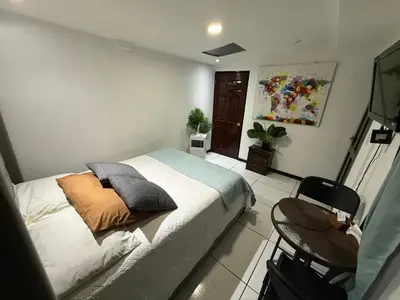 a bedroom with a bed and a chair in it at Alojamiento Cereza 1 in Alajuela City