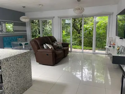 a living room with a couch and a table at Brisa del Río Santa Ana in Río Oro
