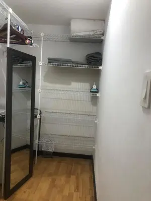 a walk in closet with white shelves and a mirror at Brisa del Río Santa Ana in Río Oro