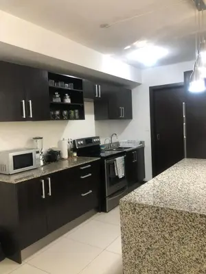 a kitchen with black cabinets and a counter top at Brisa del Río Santa Ana in Río Oro