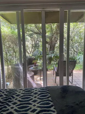 a screened in porch with a bed and a patio at Brisa del Río Santa Ana in Río Oro