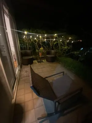 a bench on a patio at night with lights at Brisa del Río Santa Ana in Río Oro