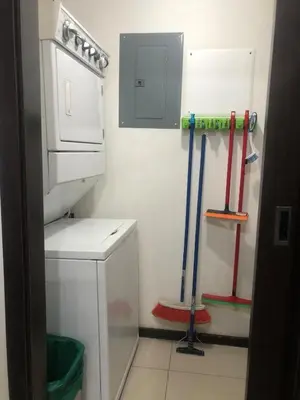 a small bathroom with a washer and mop at Brisa del Río Santa Ana in Río Oro