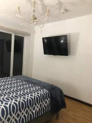 a bedroom with a bed and a flat screen tv on the wall at Brisa del Río Santa Ana in Río Oro