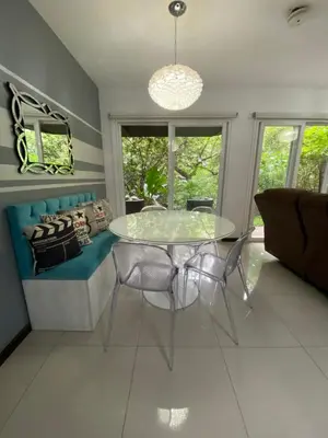 a dining room with a glass table and a couch at Brisa del Río Santa Ana in Río Oro
