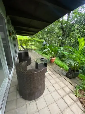 a patio with chairs and a table and plants at Brisa del Río Santa Ana in Río Oro