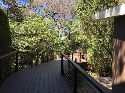 a wooden walkway leading into a forest with trees at Brisa del Río Santa Ana in Río Oro