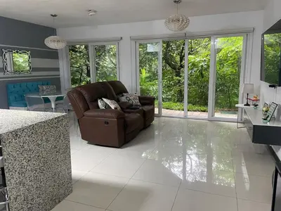 a living room with a couch and a table at Brisa del Río Santa Ana in Río Oro