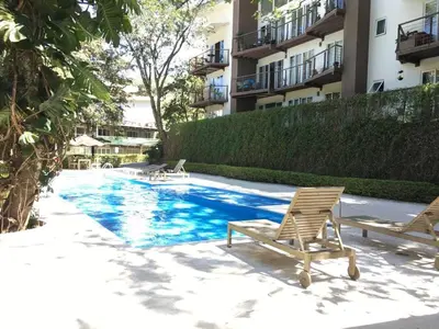 a swimming pool with two lounge chairs next to a building at Brisa del Río Santa Ana in Río Oro