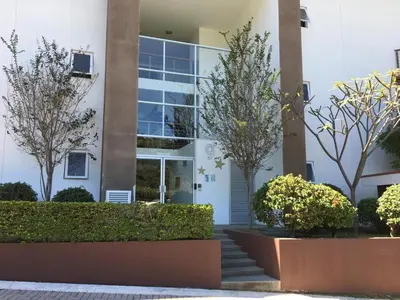 a white building with trees in front of it at Brisa del Río Santa Ana in Río Oro