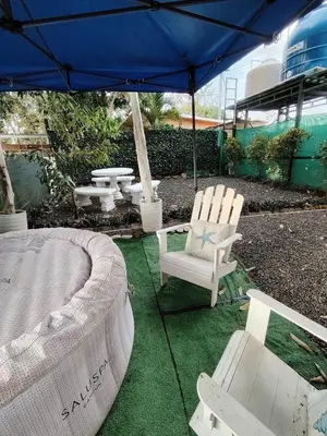 a patio with two chairs and a table and an umbrella at Villa jr 1 Private Jacuzzi near peñon guacalillo in Tivives