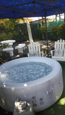 a jacuzzi tub in a yard with chairs and an umbrella at Villa jr 1 Private Jacuzzi near peñon guacalillo in Tivives