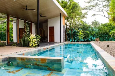 a swimming pool in front of a house at Oshy Sunset Apartments - 10 mins from Tamarindo in Villarreal