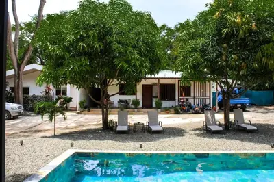 a swimming pool in front of a house with trees at Oshy Sunset Apartments - 10 mins from Tamarindo in Villarreal