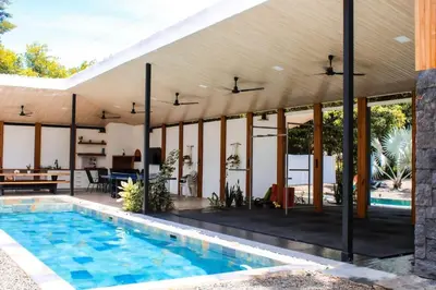 an external view of a house with a pool at Oshy Sunset Apartments - 10 mins from Tamarindo in Villarreal