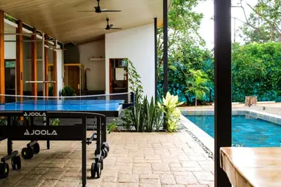 a tennis court in front of a house with a swimming pool at Oshy Sunset Apartments - 10 mins from Tamarindo in Villarreal