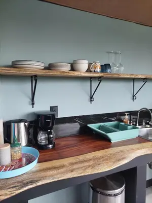a kitchen counter with a sink and plates on shelves at Arenal volcano apartment with panoramic view in El Castillo de La Fortuna