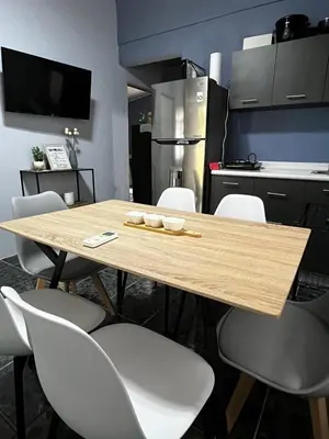 a kitchen with a wooden table and white chairs at Paraiso Valle Azul in Puntarenas