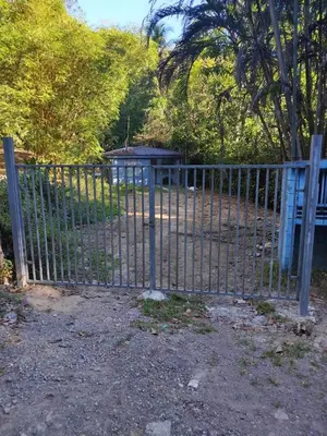a metal fence with a gate in a park at Paraiso Valle Azul in Puntarenas