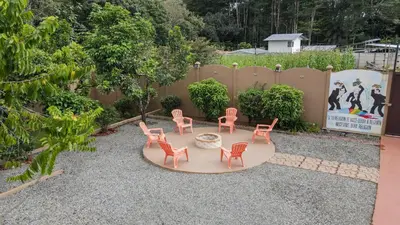 a patio with pink chairs and a circular table at Quinta Issazu in Juntas