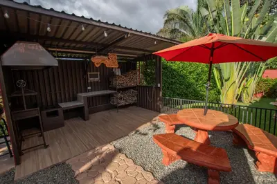 a patio with a table and a red umbrella at Quinta Issazu in Juntas