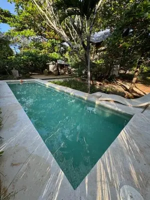 a swimming pool with green water in a yard at CASA NiCO in Río Sequito