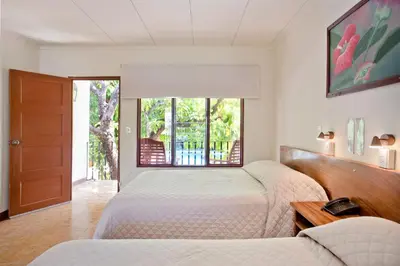 a bedroom with two beds and a window at Hotel Boyeros in Liberia