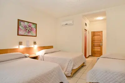 a hotel room with two beds and a door at Hotel Boyeros in Liberia