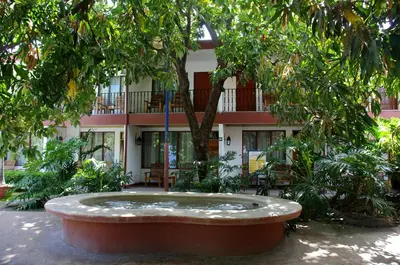 a building with a fountain in the middle of a courtyard at Hotel Boyeros in Liberia