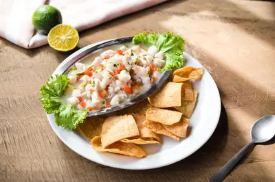 a plate of food with a bowl of dip and tortilla chips at Hotel Boyeros in Liberia