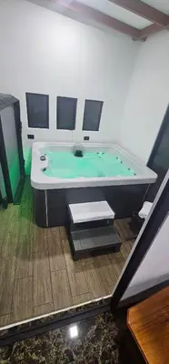 a bath tub in a room with a green pool at Historias Lodge in Monteverde Costa Rica