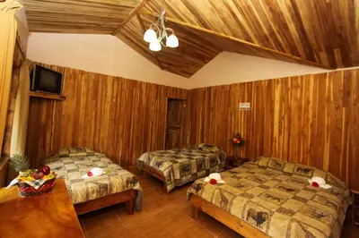 a hotel room with two beds and a tv at Historias Lodge in Monteverde Costa Rica