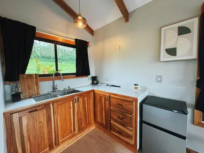 a kitchen with wooden cabinets and a sink and a window at EcoVilla with Pool & HotSprings in Fortuna