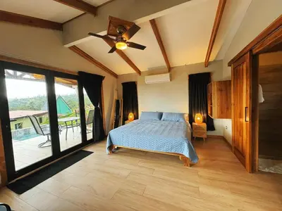 a bedroom with a bed and a ceiling fan at EcoVilla with Pool & HotSprings in Fortuna
