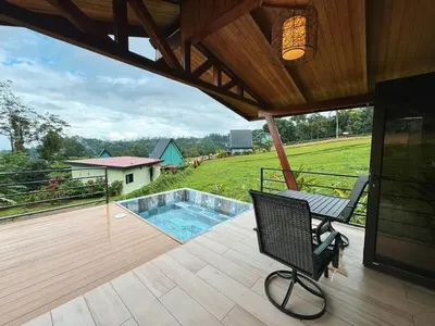 a patio with a chair and a swimming pool at EcoVilla with Pool & HotSprings in Fortuna