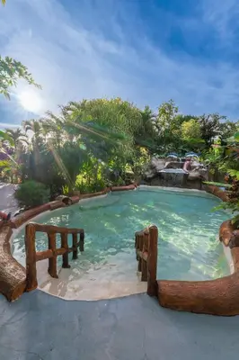 a large swimming pool with a bench in it at EcoVilla with Pool & HotSprings in Fortuna