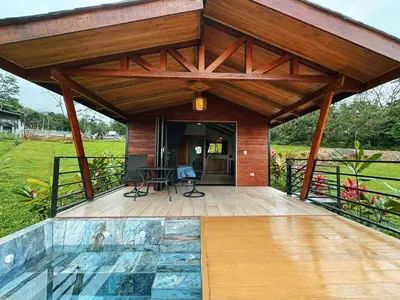 a pavilion with a pool in front of a house at EcoVilla with Pool & HotSprings in Fortuna