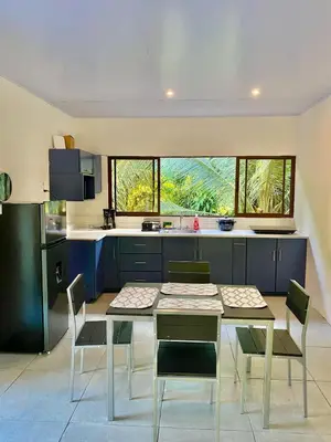 a kitchen with a table and chairs in a room at Casa El Rio in Estero