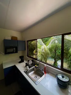 a kitchen with a sink and a large window at Casa El Rio in Estero