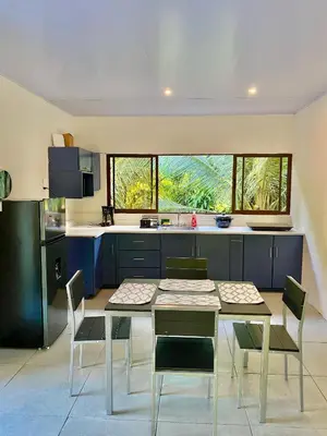 a kitchen with a table and chairs in a room at Casa El Rio in Estero
