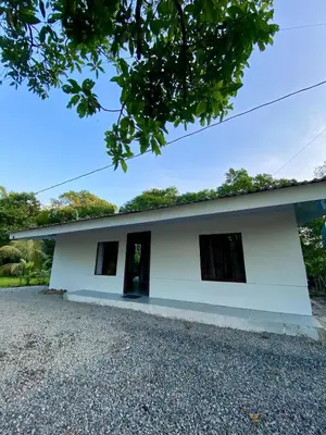 a white building with two windows on the side at Casa El Rio in Estero