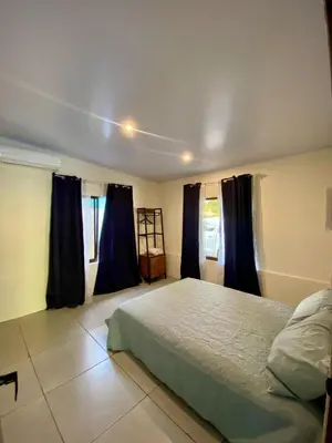 a bedroom with a bed and blue drapes at Casa El Rio in Estero