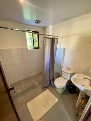 a bathroom with a shower and a toilet and a sink at Casa El Rio in Estero